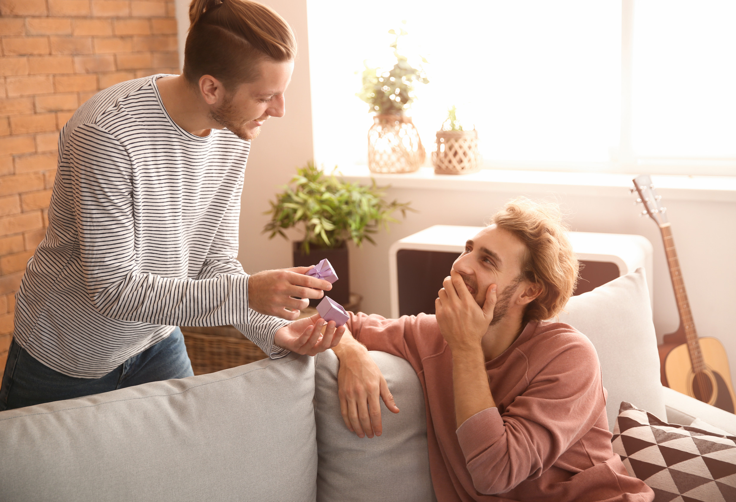 Man surprising his boyfriend with a present