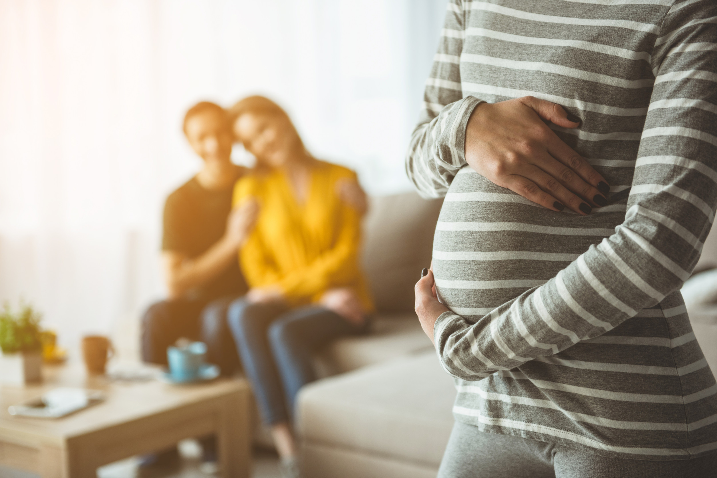 Future parents looking at surrogate expectant mother