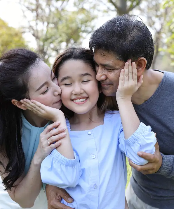image of happy family, daughter putting her hands on parents cheek with smiling while father and mother kissing during summer time in the park image of happy family, daughter putting her hands on parents cheek with smiling while father and mother kissing during summer time in the park
